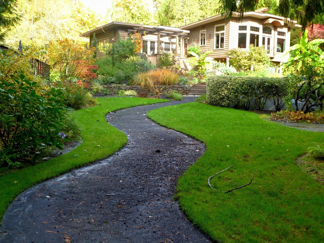 Jardin avec une allée menant à une grande maison